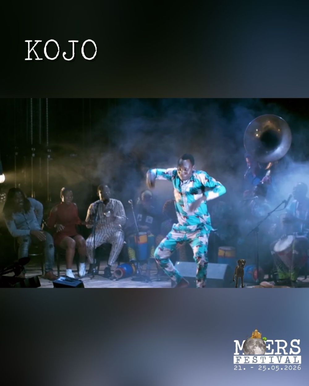 A Black dancer in a colorful outfit dances on a stage. His name, "KOJO," is in the upper left corner, and the Moers Festival logo is in the lower right.